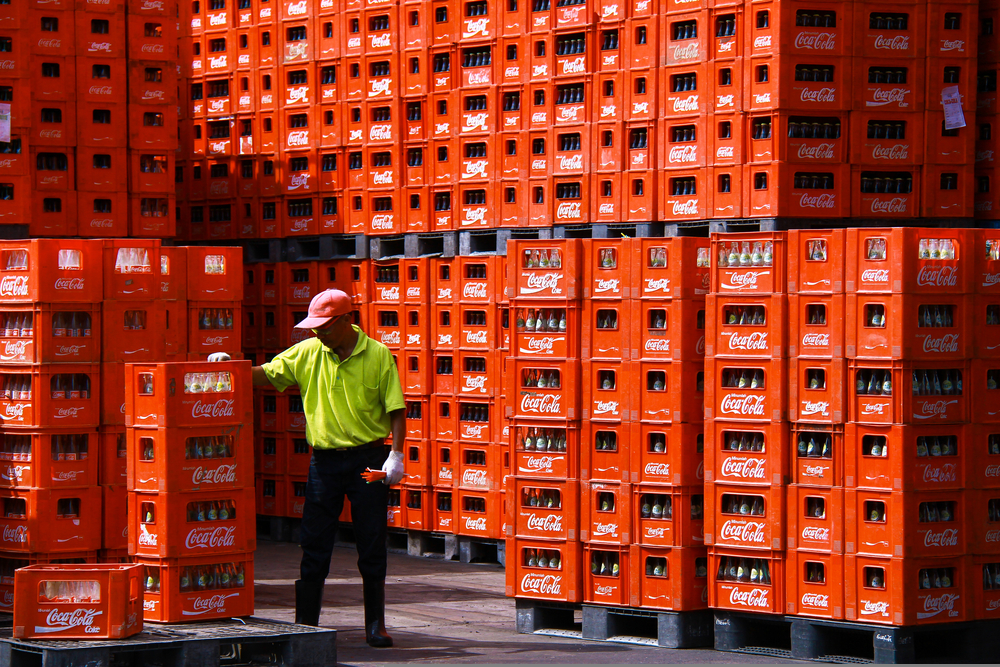 Coca cola supply chain: A worker control a stack of crates of empty Coca-Cola bottle.