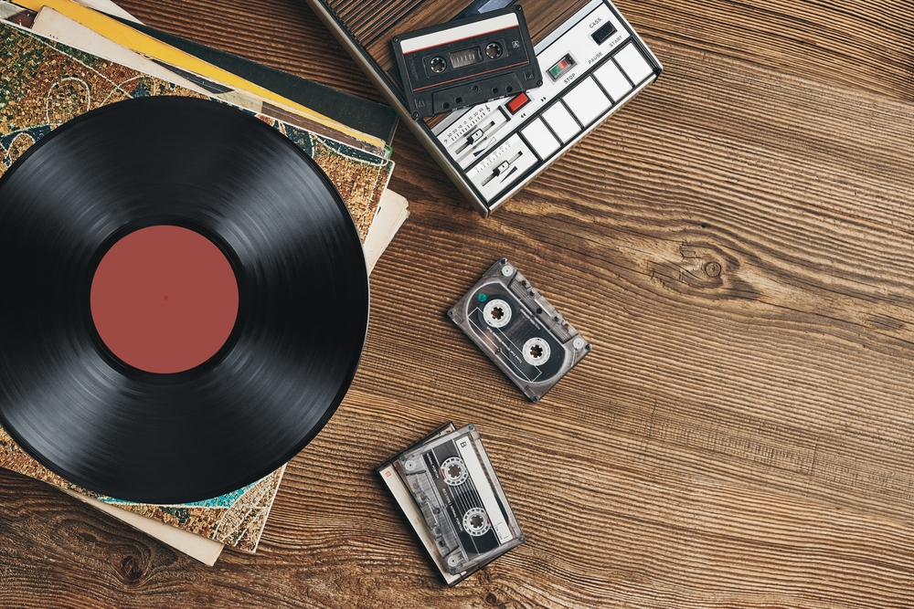 Vinyl records, cassette tapes and cassette recorder on wooden table. Retro music style. 80s music party. Vintage style. Analog equipment. Stereo sound. Back to the past The music manufacturer joins companies such as Tilda and L’Occitane Group to receive a B Corp certification.