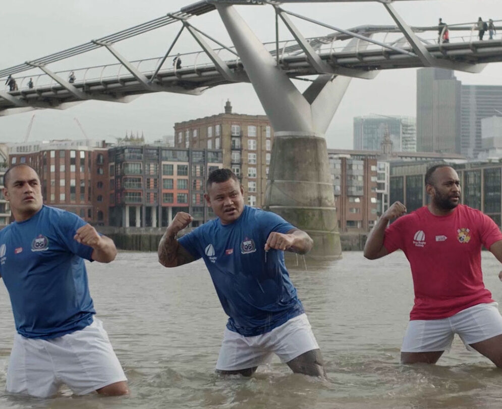 Three Rugby players knee-deep in River Thames. Rugby World Cup