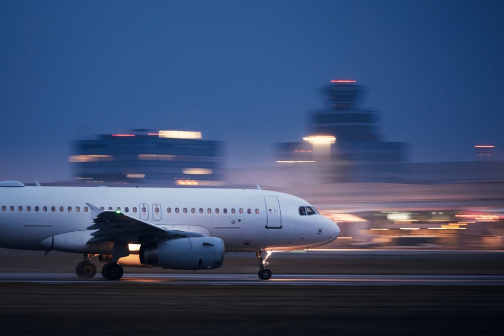 Airplane during take off on airport runway at night against air traffic control tower. Plane in blurred motion at night. Campaigners have released an open letter stating they’re “deeply concerned” about the Science Based Targets initiative (SBTi)’s work on aviation.