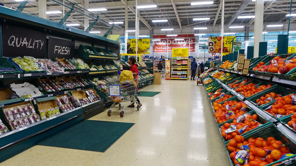 Shoppers browse an aisle in a Tesco supermarket.